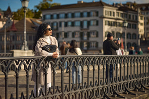 Lady over looking the city with her yves saint laurent handbag held closely